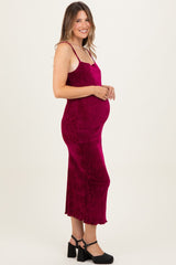 woman wearing a fuchsia maternity slip dress with spaghetti straps and a visible baby bump