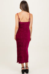 woman wearing a fuchsia spaghetti strap maternity dress with a fitted silhouette and midi length