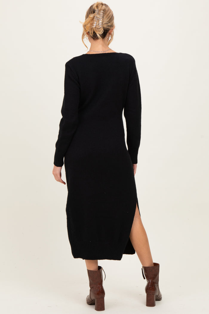 woman wearing a black maternity sweater dress with side slits and long sleeves, styled with brown heeled boots