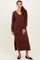 woman wearing a burgundy long sleeve knitted maxi dress with a v-neck and side slit