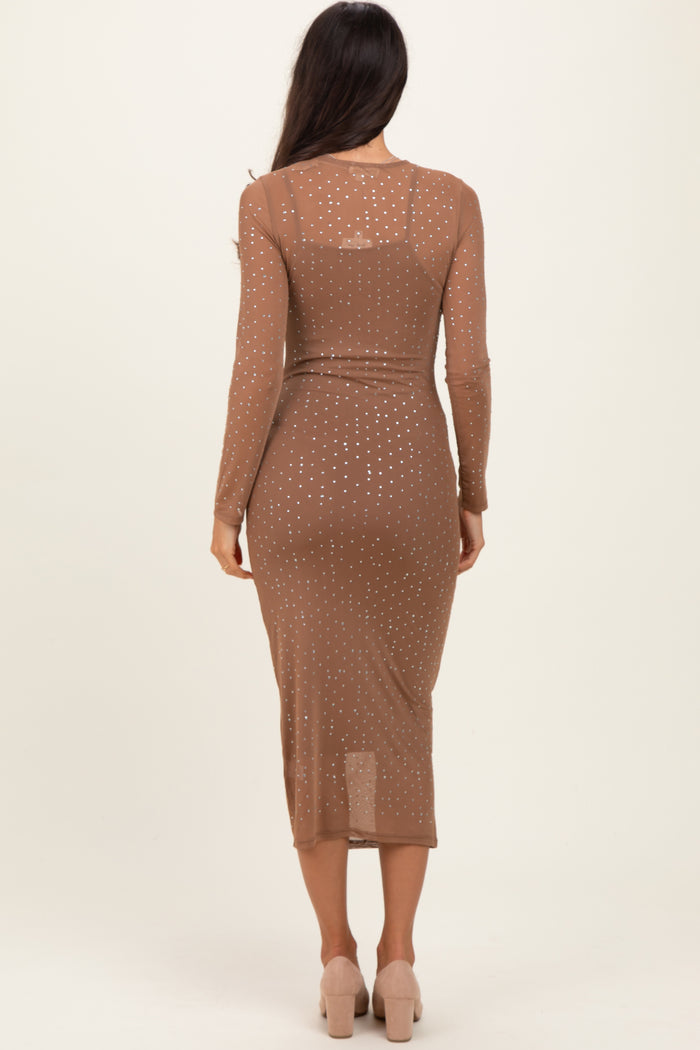 woman wearing a brown long sleeve midi dress with polka dot pattern and a fitted silhouette