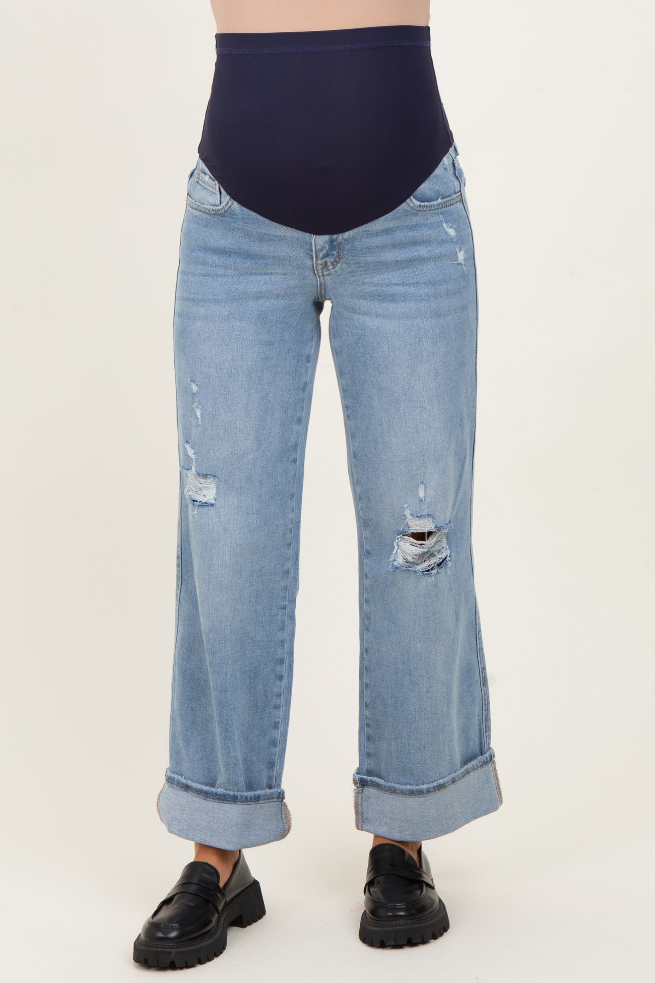 woman wearing distressed light blue wide-leg maternity jeans with a navy fitted belly panel