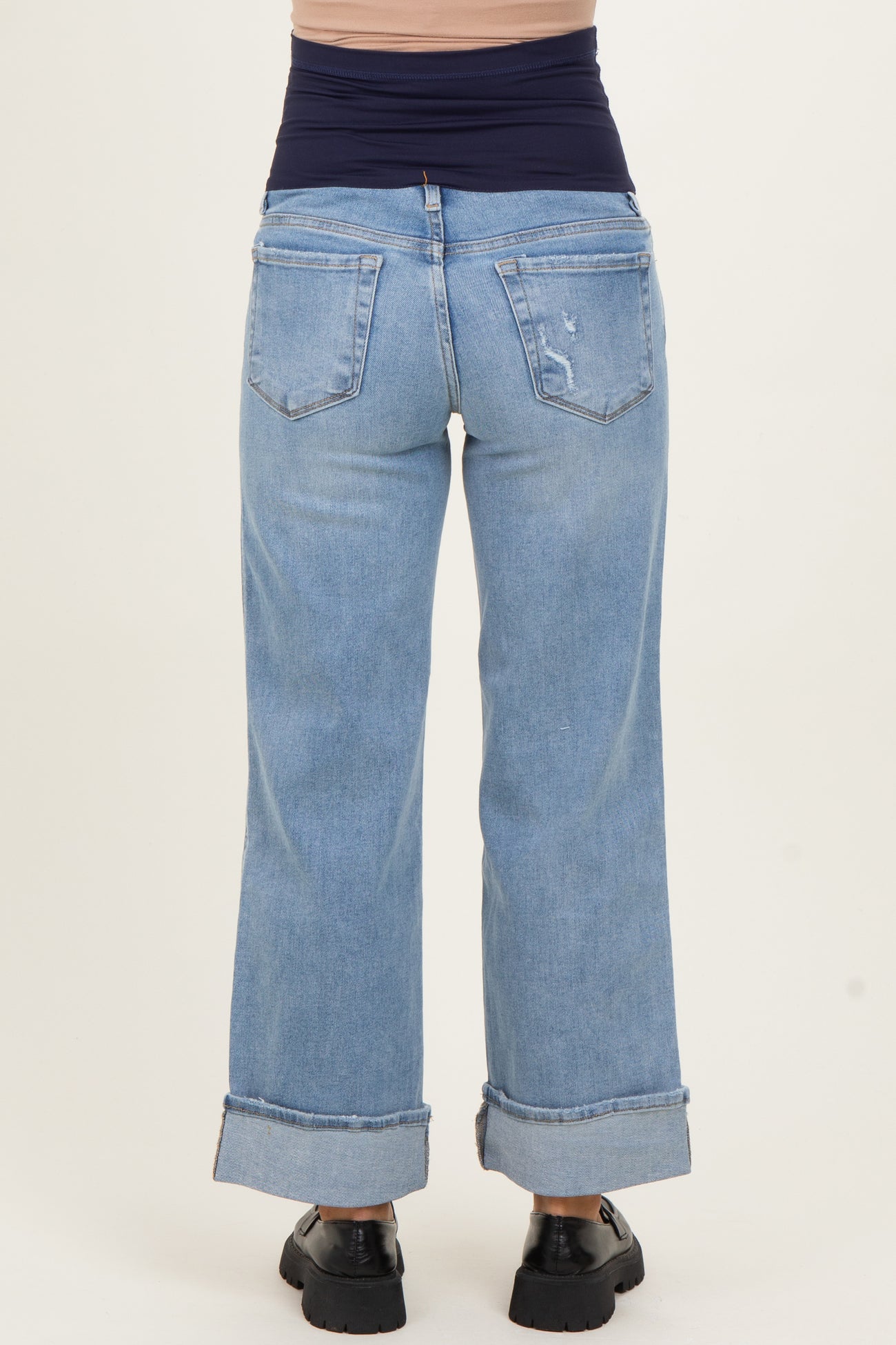 woman wearing light blue maternity wide-leg jeans with a high waistband and cuffed hems, view from the back