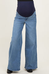 woman wearing a pair of light blue wide-leg maternity jeans with a dark blue over-the-bump panel