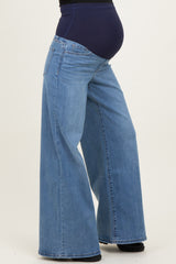 woman wearing light blue wide-leg maternity jeans with a support waistband and visible baby bump