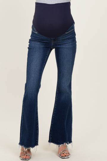 woman wearing dark blue maternity flared jeans with a navy blue over-the-belly band and frayed hem
