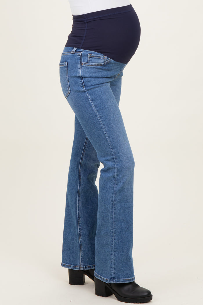 woman wearing dark wash maternity flared jeans with a navy blue waistband and visible baby bump