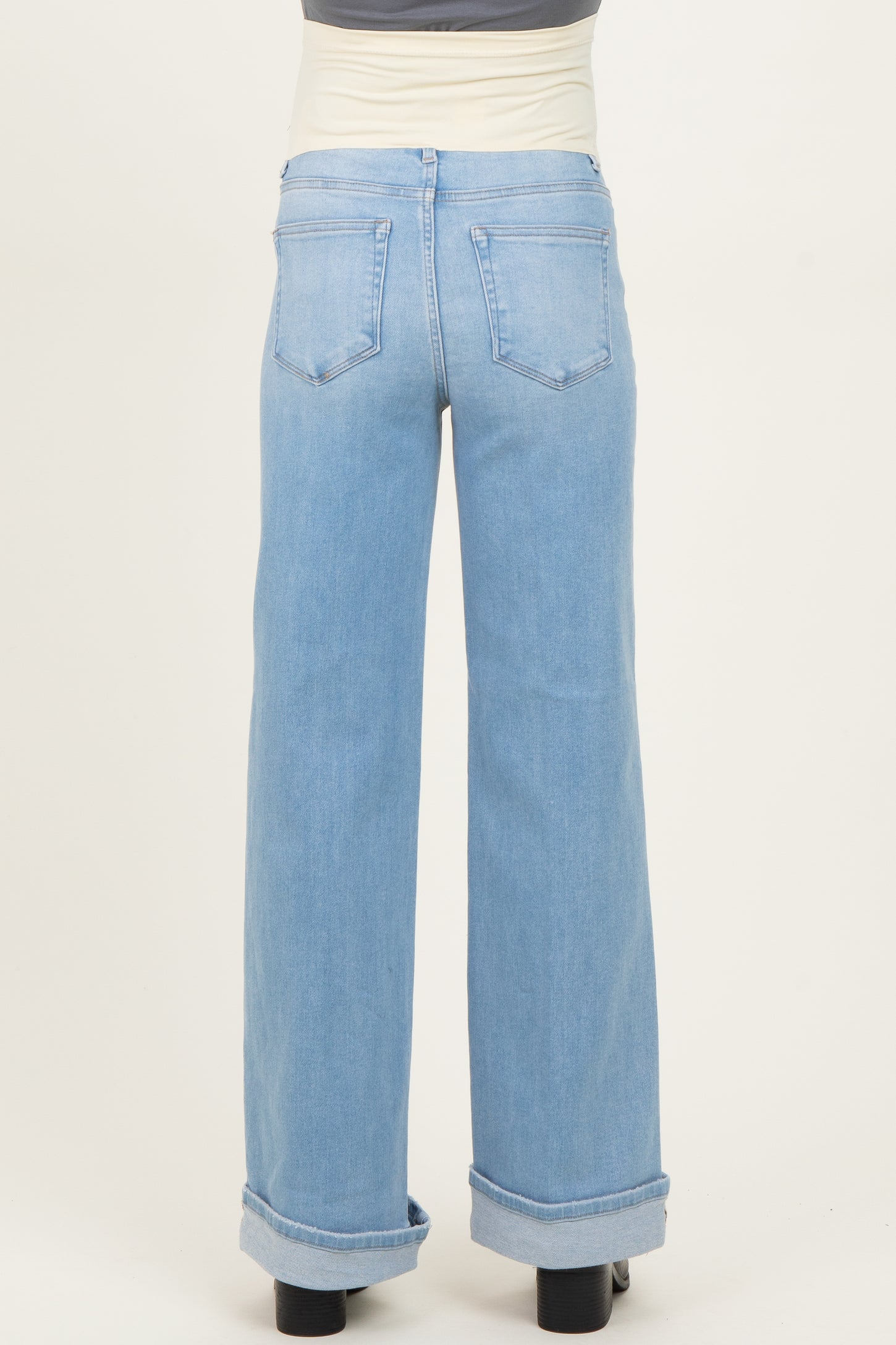 maternity wear light blue wide-leg jeans with a high waist and cuffed hems, shown from the back