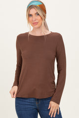 woman wearing a brown long sleeve top with a scoop neckline and denim jeans, styled with a headscarf