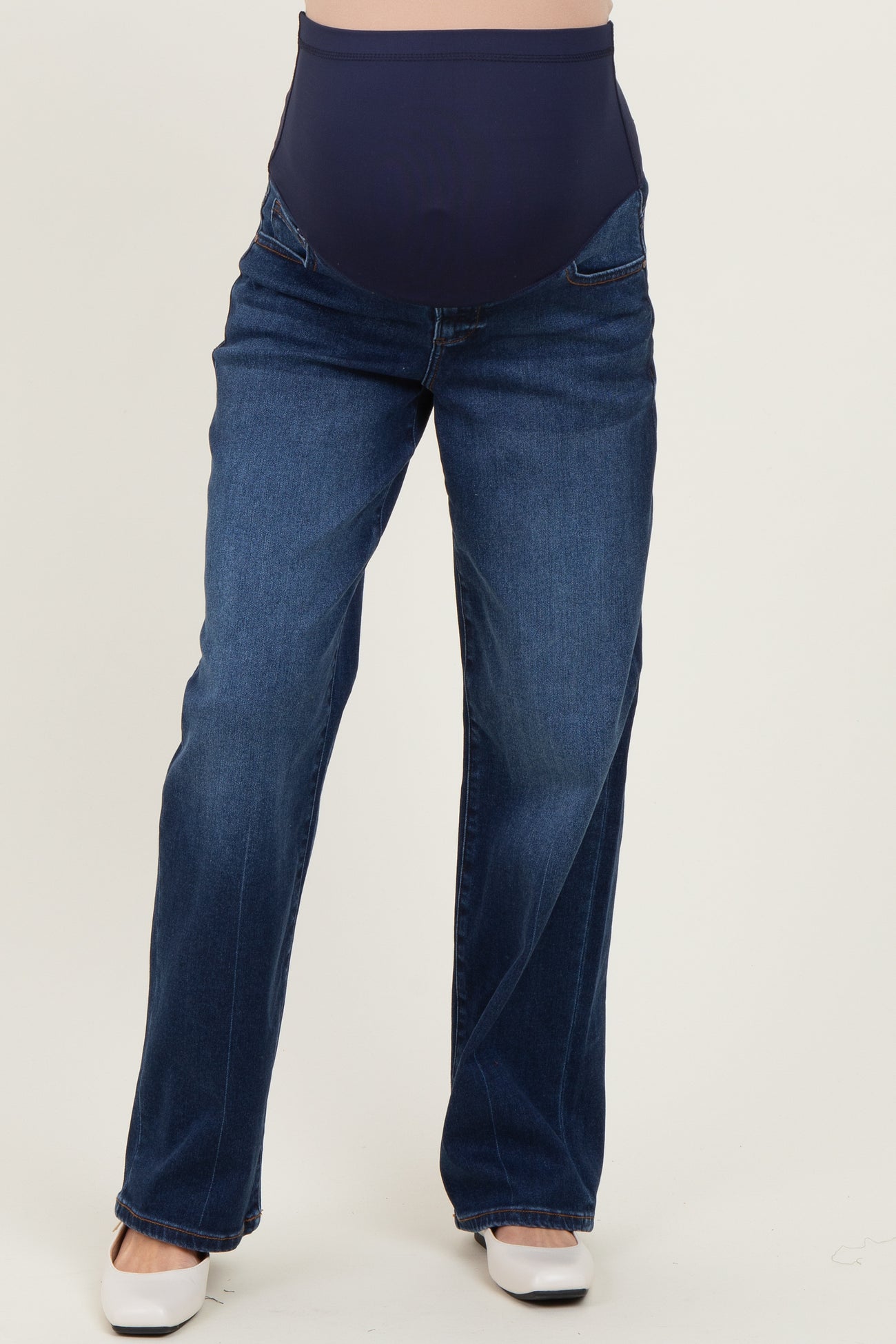 woman wearing dark blue maternity jeans with a wide elastic waistband and relaxed fit