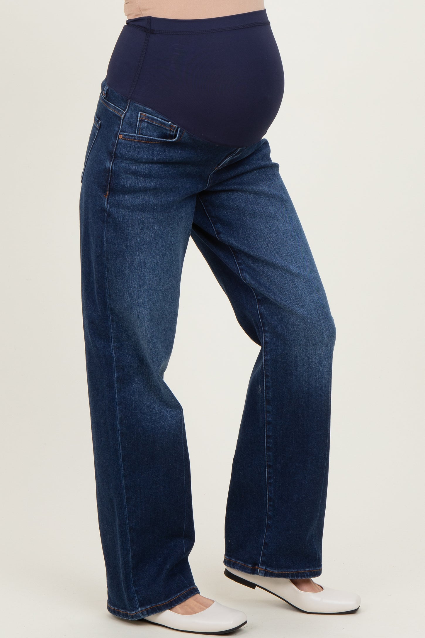 woman wearing dark blue maternity jeans with a high waistband and a visible baby bump