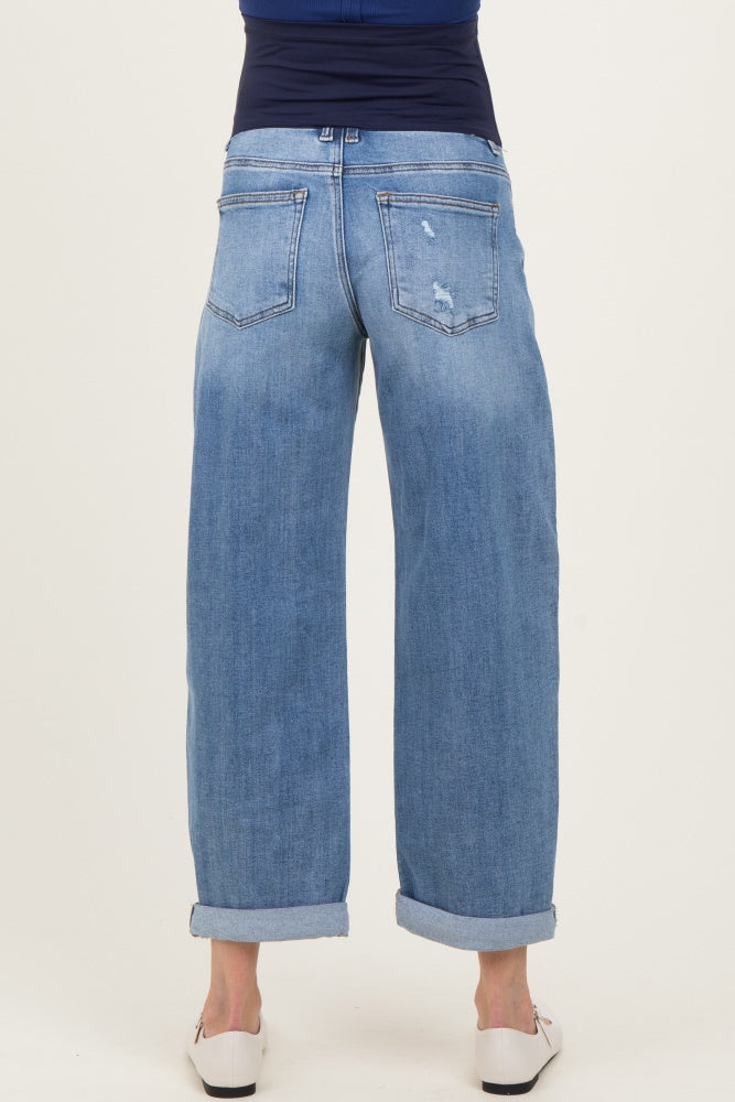 woman wearing light blue maternity wide-leg jeans, shown from the back with rolled cuffs and a distressed detail