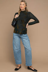 woman wearing a dark green maternity long sleeve top with floral print and distressed light blue maternity jeans