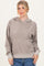 woman wearing a tan oversized hoodie with a front pocket and adjustable drawstring hood