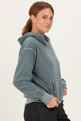 woman wearing a gray hooded sweatshirt with a front pocket and a relaxed fit
