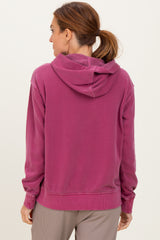 woman wearing a pink hoodie with a relaxed fit and a drawstring hood, viewed from the back