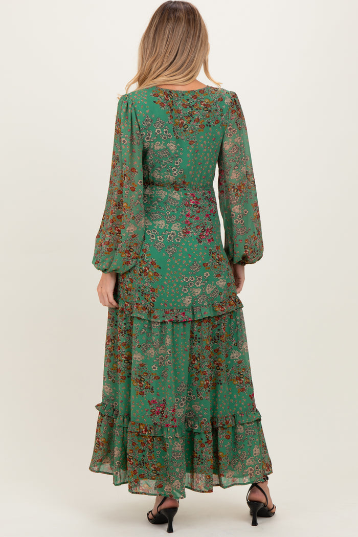 woman wearing a green floral maternity maxi dress with long sleeves and ruffle details