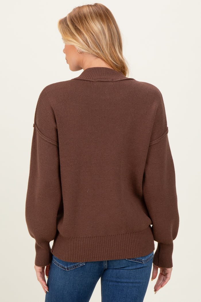 woman wearing a brown maternity sweater with a relaxed fit and oversized sleeves, viewed from the back