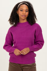 woman wearing a fuchsia oversized ribbed sweater with a high neck and long sleeves