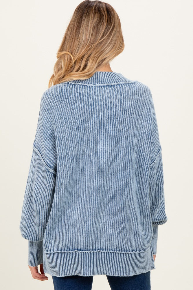 woman wearing a light blue ribbed maternity sweater with long sleeves and a relaxed fit, shown from the back