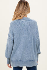 woman wearing a light blue ribbed maternity sweater with long sleeves and a relaxed fit, shown from the back