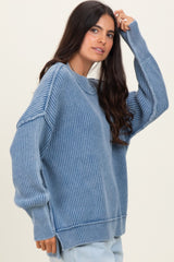 woman wearing a oversized blue ribbed sweater with long sleeves and a relaxed fit