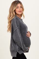 woman wearing a gray striped oversized maternity sweater and holding her baby bump