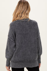 woman wearing a dark gray maternity sweater with ribbed texture and oversized fit, seen from the back