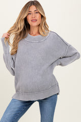 woman wearing a gray ribbed maternity sweater with a loose fit and visible baby bump, paired with blue jeans