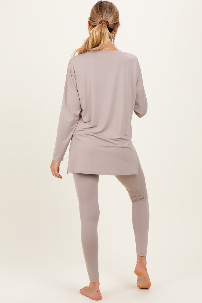 woman wearing a light grey maternity long sleeve top and matching leggings, showing a relaxed fit from the back