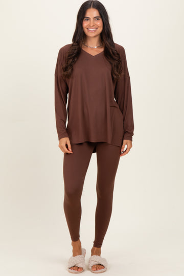 woman wearing a brown long sleeve v-neck top and matching leggings, styled casually with fluffy slippers