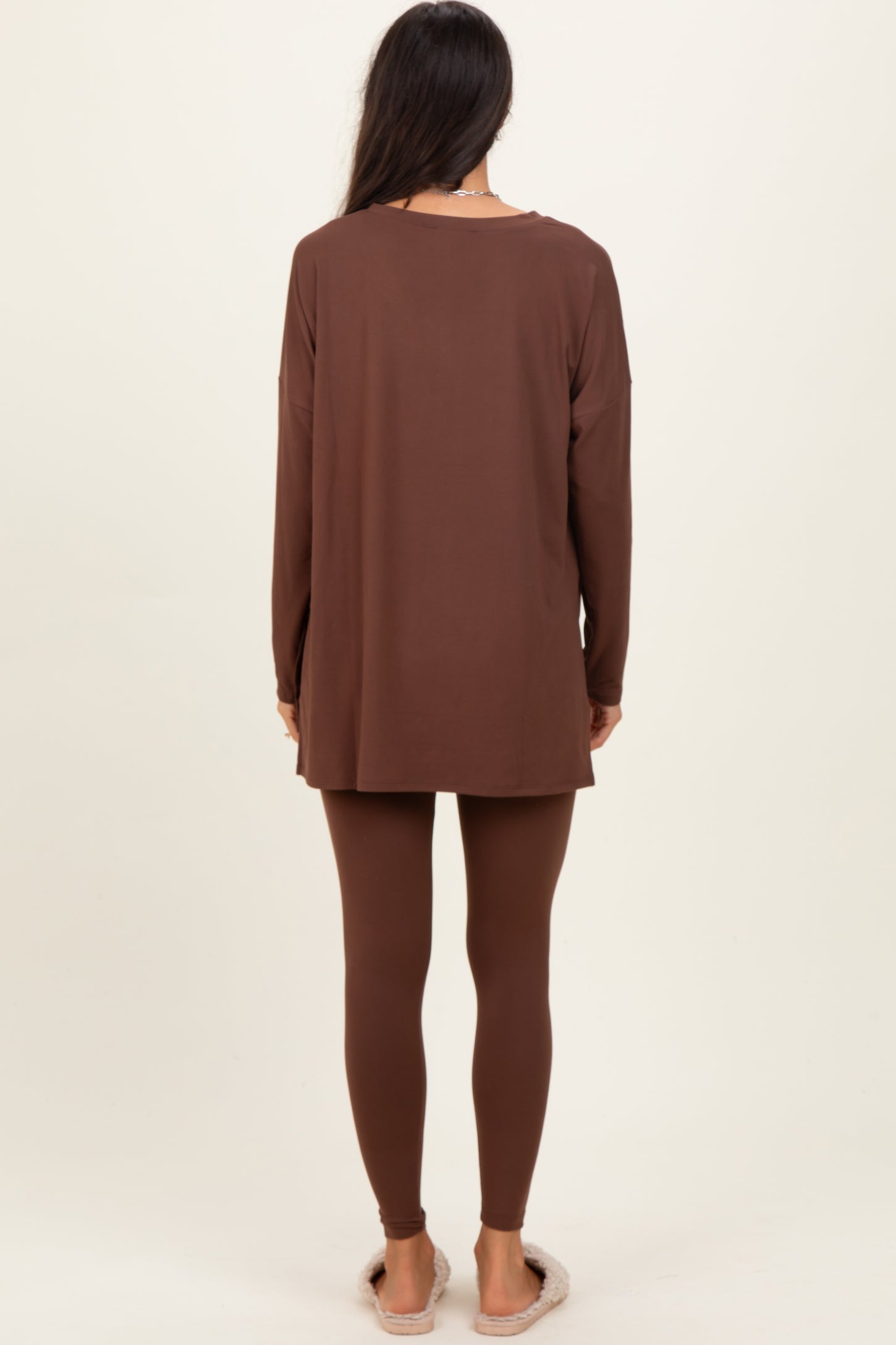 woman wearing a long brown tunic top and matching leggings, viewed from the back