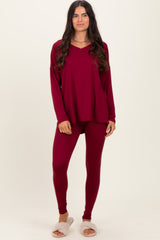 woman wearing a burgundy long sleeve top and matching leggings with cozy slippers on her feet