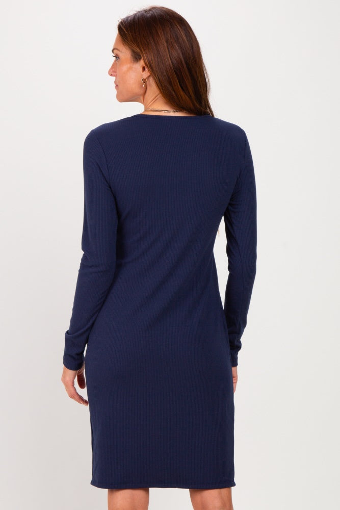 woman wearing a long sleeve navy ribbed dress, viewed from the back