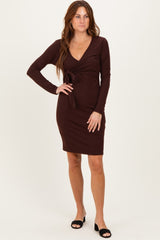 woman wearing a burgundy long sleeve wrap dress with a tie detail at the waist
