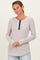 woman wearing a light gray ribbed long sleeve top with a button neckline and relaxed fit