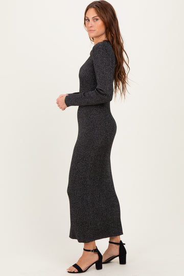 woman wearing a fitted black long sleeve maxi dress with a textured pattern and strappy black heels