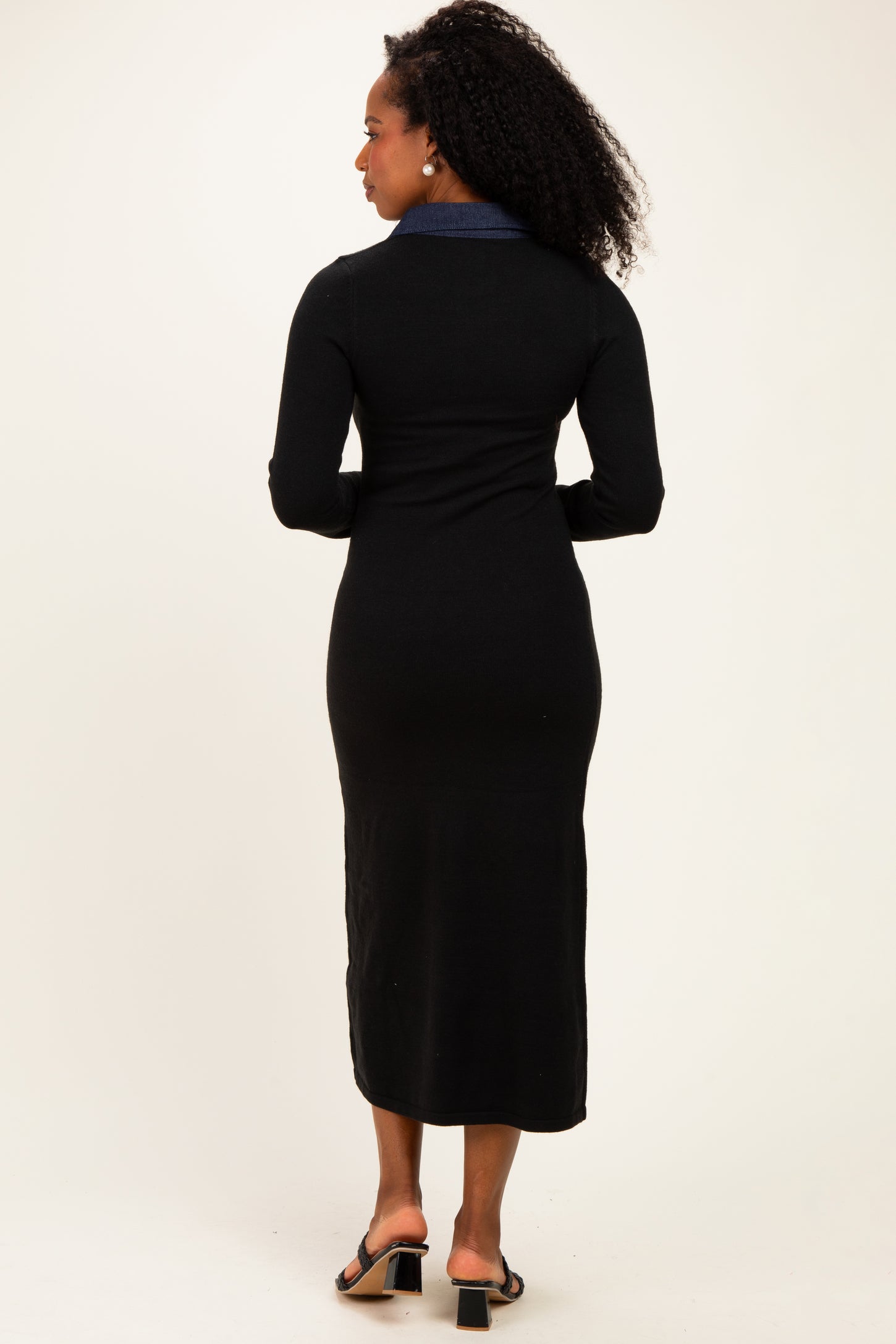 woman wearing a black long sleeve midi dress with a denim collar, seen from the back