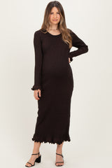 woman wearing a dark brown long sleeve maternity dress with ruffled hem and cuffs, showing her baby bump