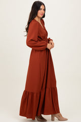 woman wearing a rust long sleeve maxi dress with a tiered hem and a v-neckline
