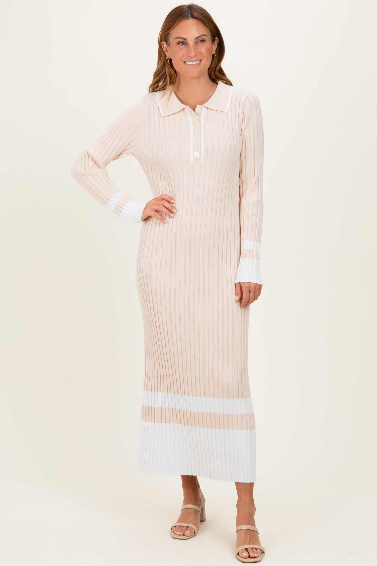 woman wearing a beige and white ribbed knit maxi dress with a collar and long sleeves