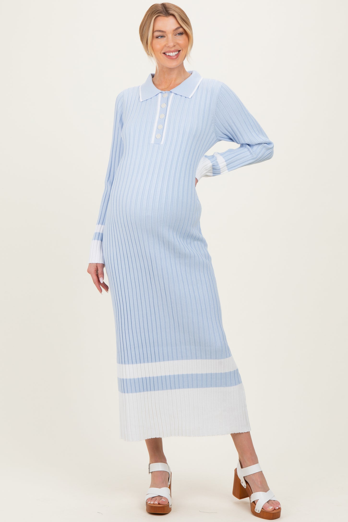 woman wearing a light blue striped maternity dress with a collared neckline and long sleeves, showing her baby bump