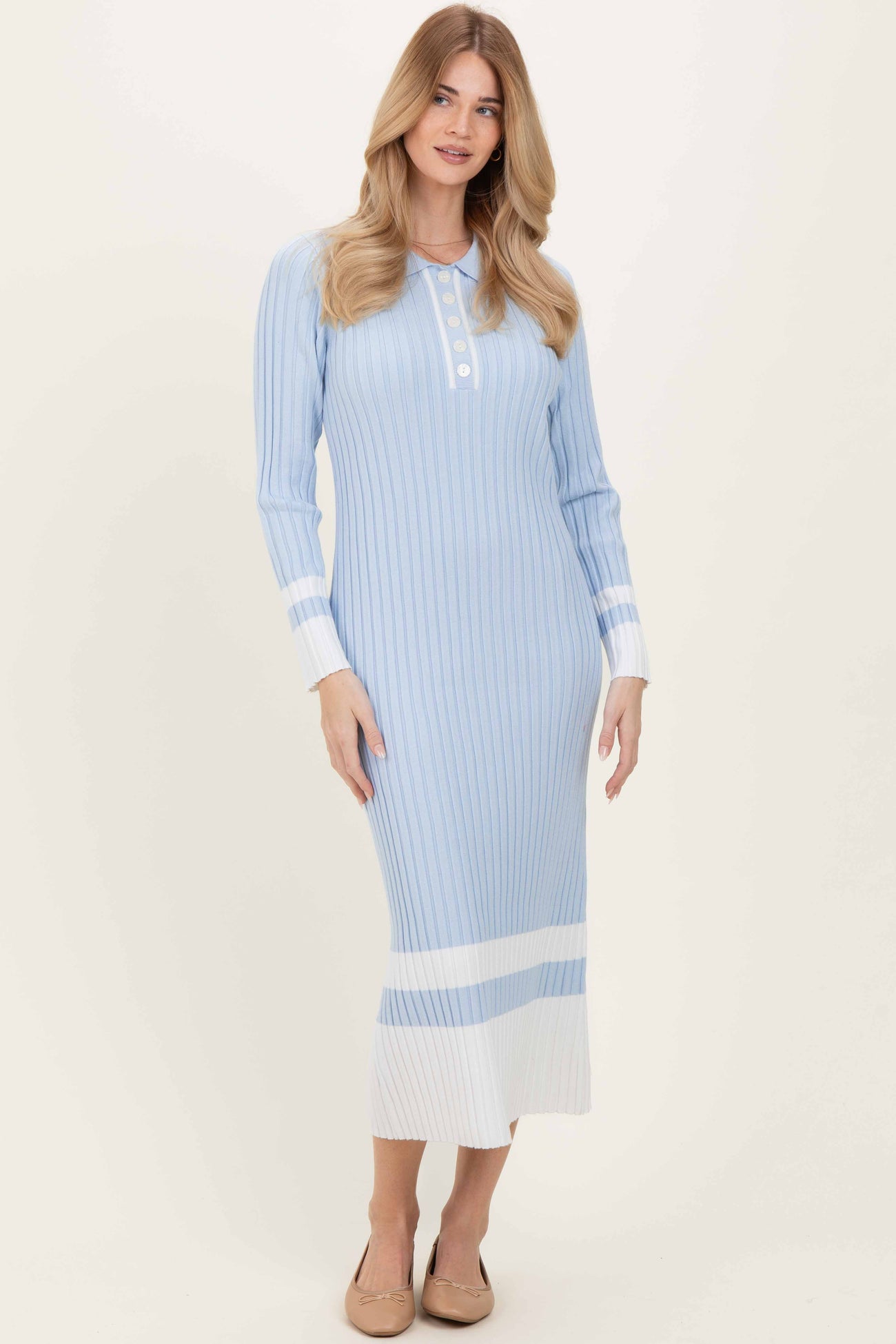woman wearing a light blue ribbed midi dress with long sleeves and button details