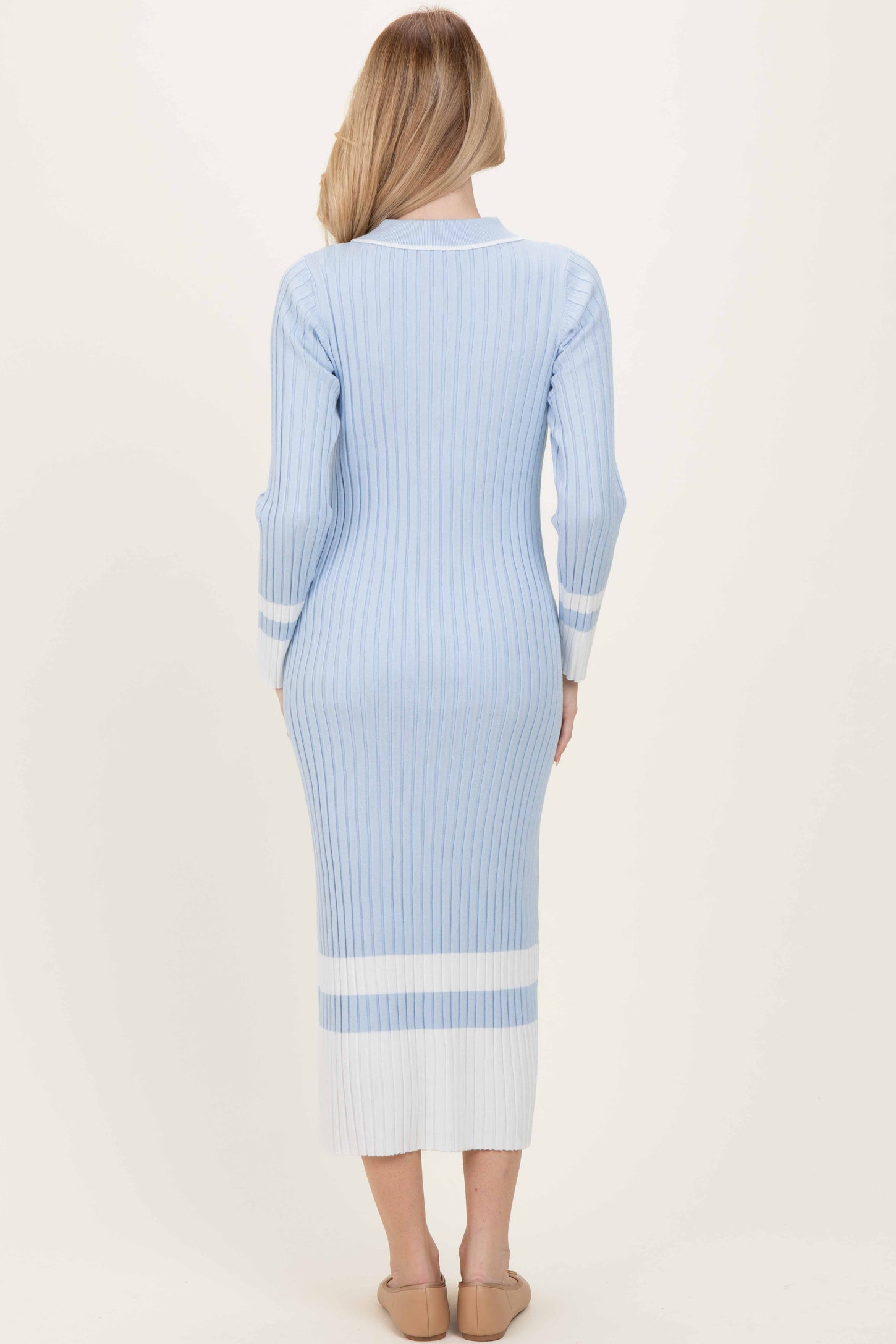 woman wearing a light blue ribbed midi dress with long sleeves and white stripe accents