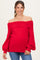 woman wearing a red off-the-shoulder maternity sweater with balloon sleeves and a fitted bottom, showcasing her baby bump