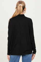 woman wearing a black maternity top with a relaxed fit and long sleeves, seen from the back