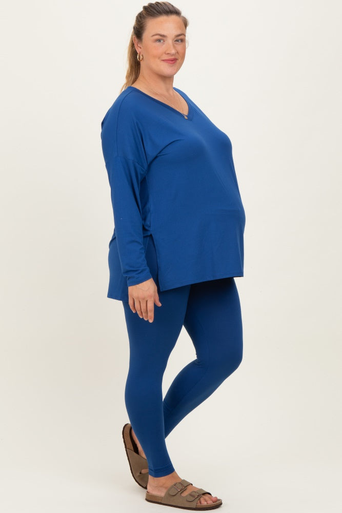 woman wearing a royal blue maternity top and matching leggings, showing her baby bump