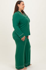 woman wearing a green plus size pajama set with long sleeves and pants, featuring white contrasting details
