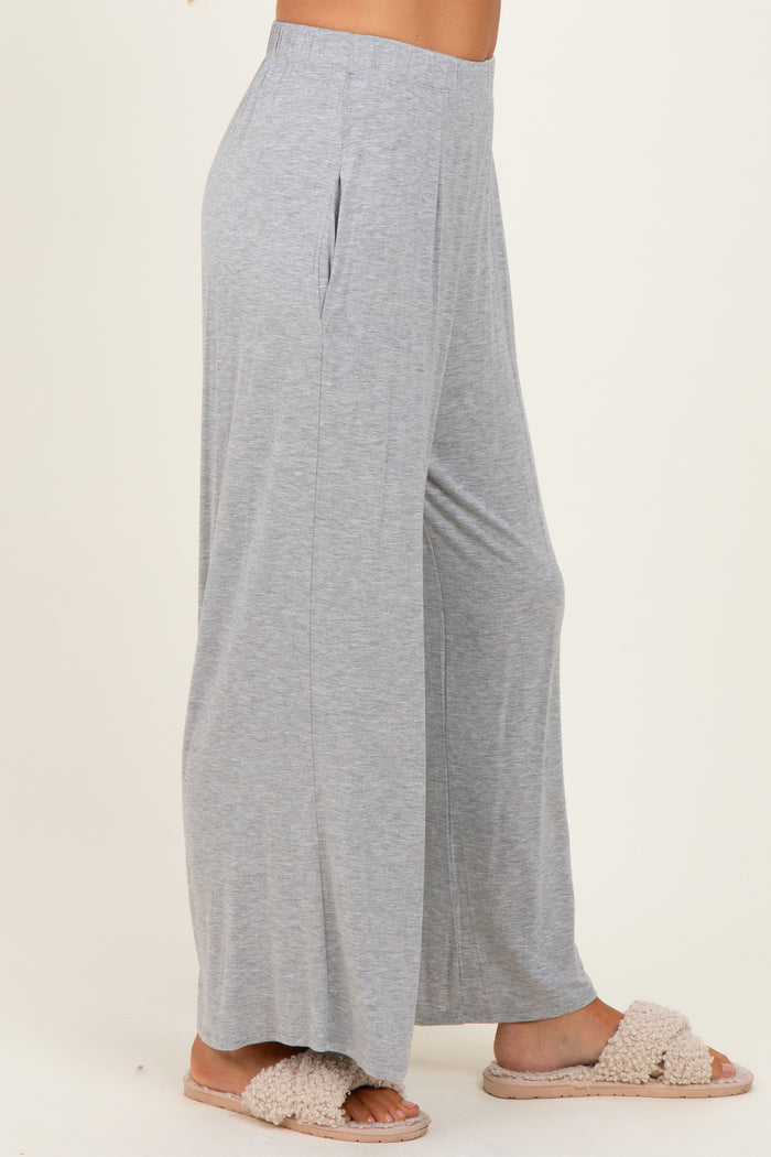 woman wearing light gray wide leg lounge pants with side pockets and fluffy slippers
