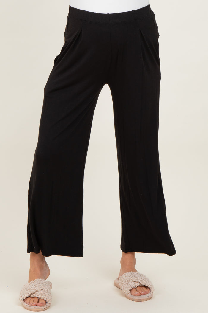 maternity wear black wide-leg pants with side pockets, styled with cozy beige slippers